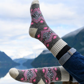 Person wearing patterned socks with a mountainous landscape in the background
