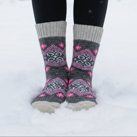 Gray and pink patterned socks worn in the snow