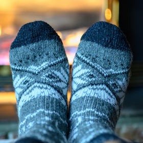 Pair of gray and blue patterned socks with a blurred background
