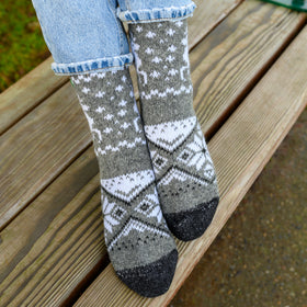 Person wearing patterned socks on a wooden bench