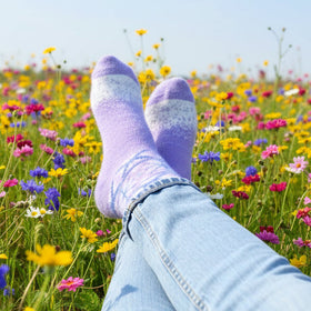 Purple socks and jeans in a field of colorful flowers