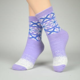Purple socks with a blue and white pattern worn by a person on a gray background
