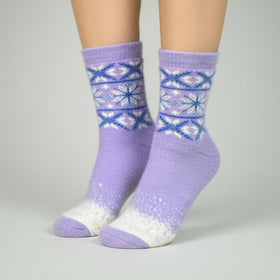 Purple patterned socks worn by a person on a gray background