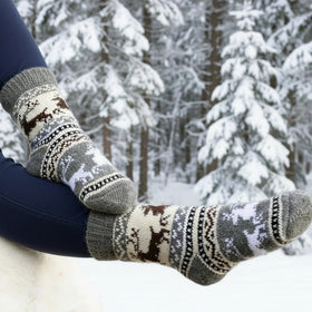 Person wearing patterned socks in a snowy forest setting
